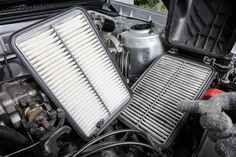 the engine compartment of a car with two air filters on it's hood and an open canister