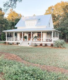 a white house with a blue roof and porch