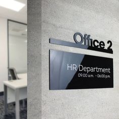 an office sign on the wall next to a desk