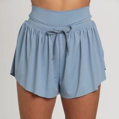 Best Selling Go-With-The-Flow Athletic Shorts Are Designed To Be Totally Versatile. The Smooth, Cool Athletic Material Can Handle Any Workout Or Is Comfortable For Everyday Wear. These Shorts Feature A Flowy, Butterfly Side Cut Design And A High Waisted Drawstring Waist Band. They Are Complete With Built-In Spandex Shorts With Side Pockets For Functionality. Spandex Lined Shorts Comfort Waist Band Drawstring Waist Tie Hidden Side Pockets Machine Wash Cold Wash With Like Colors Tumble Low Dry Do Workout Shorts With Pockets, Summer Workout Bottoms With Built-in Shorts, Blue Athleisure Bottoms With Built-in Shorts, Light Blue Bottoms With Built-in Shorts And Relaxed Fit, Versatile Athletic Shorts For Yoga In Summer, Summer Activewear With Relaxed Fit And High Waist, Spring Workout Bottoms With Built-in Shorts, Solid Color Short Bottoms For Yoga, Light Blue Sports Shorts For Summer