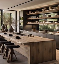 a large kitchen with wooden counter tops and stools next to an island in the middle