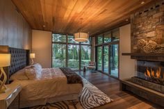 a bedroom with a fireplace and large windows