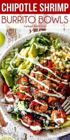 a white bowl filled with shrimp, lettuce and tomato salad next to lime wedges