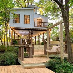 a house built into the side of a tree with stairs leading up to it's roof