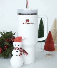 a white coffee mug with a snowman and santa hat on it