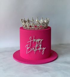 a pink birthday cake with a tiara on top and happy birthday written on it