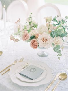 the table is set with white and pink flowers