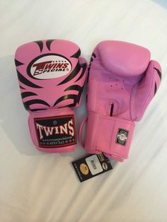 two pink boxing gloves sitting on top of a white bed next to a tag that says twins special