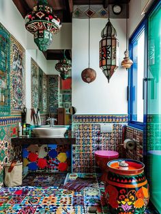 a bathroom with colorful tiles and lights hanging from the ceiling, along with a sink