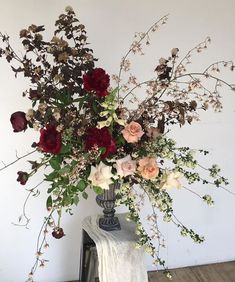 a vase filled with lots of flowers on top of a table