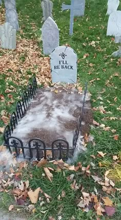 a cemetery with tombstones and headstones in the grass covered in snow, surrounded by fallen leaves