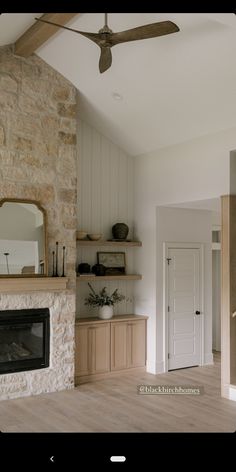 a living room filled with furniture and a fire place in front of a stone wall