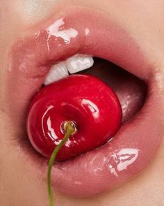 a woman's lip with a piece of fruit sticking out of her mouth and tongue