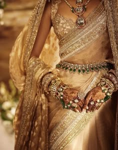 a woman in a bridal outfit with jewelry on her hands