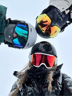 a person wearing skis and goggles standing in the snow with their hands up