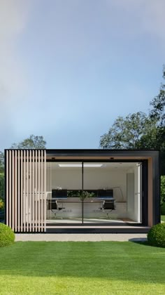 an open room with sliding glass doors in the middle of a grassy area next to trees