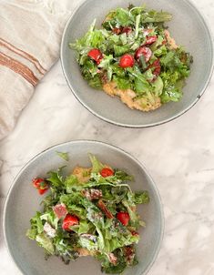 two plates filled with salad on top of a table