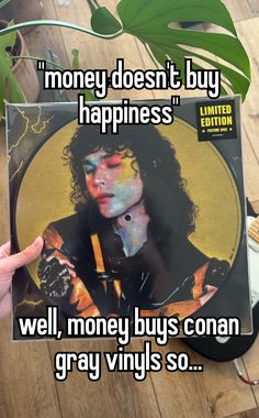 someone holding up a cd with the words money doesn't buy happiness well, money buys