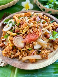 a plate filled with rice and vegetables on top of a leafy green tablecloth