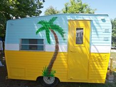 a yellow and white trailer with a palm tree painted on it