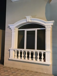 an open window on the side of a building with white railings and balconies