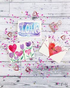 valentine's day cards and confetti on white wood