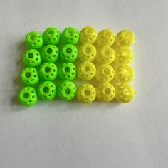 several yellow and green plastic beads sitting next to each other on a white table top