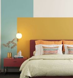 a large bed sitting in a bedroom next to a wall painted with different colors on it