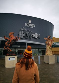 a woman standing in front of the entrance to harry potter