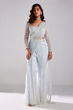 Ice blue pre-draped pant saree with cutdana and sequins embroidery. Paired with a blouse with all over sequins and cutdana embroidery in geometric pattern.
Components: 2
Pattern: Embroidery
Type Of Work: Cutdana, Sequins
Neckline: Square Neck
Sleeve Type: Full Sleeves
Fabric: Satin Lycra, Tulle and Shantoon
Color: Blue
Other Details: 
Note: All the jewellery worn by the model is not for sale
Occasion: Sangeet - Aza Fashions Pant Sari Style, Square Neck Full Sleeve Blouse, Pre Draped Saree Gown, Pant Saree Style, Square Neck Saree Blouse, Pants Saree, Sona Mohapatra, Saree With Pants, Full Sleeves Blouse