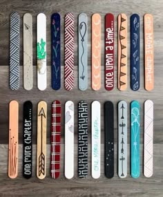 several skateboards are lined up on a wooden surface, with different designs and words painted on them