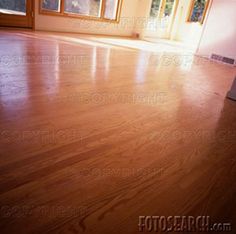 an empty room with wooden floors and windows