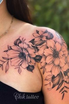 a woman's shoulder with flowers on it and a mask covering up her face