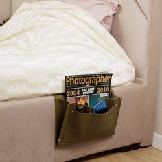 a bed with a magazine holder on the bottom and a book in it's pocket