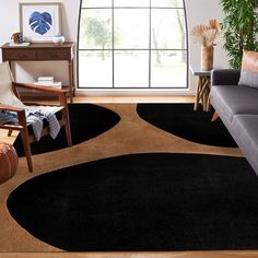 a living room with a couch, chair and rug in front of a large window