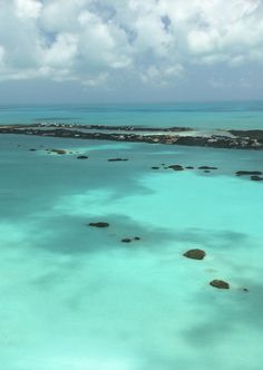 an aerial view of the ocean with rocks and water