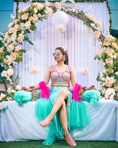 a woman sitting on top of a table in front of flowers