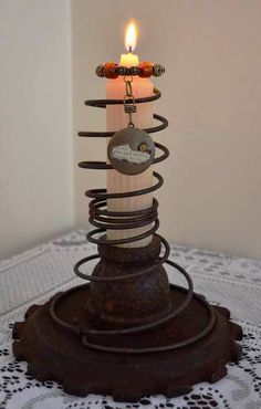 a candle that is sitting on top of a stand with some kind of wire attached to it