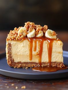 a piece of cheesecake with bananas and caramel drizzled on top