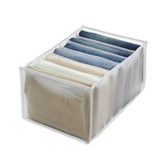 an open drawer with five folded jeans in it on a white background, showing the bottom section