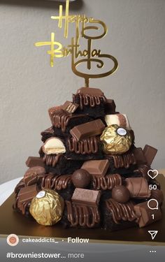 a birthday cake made to look like a pyramid with chocolates on top and gold foil lettering