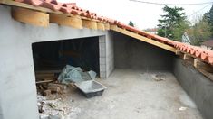 an unfinished garage is shown with the roof ripped off and debris strewn around it on the ground