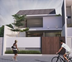 two people are riding bikes in front of a house