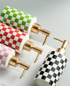 three toilet paper holders on top of an open book with checkered wrapping around them