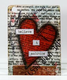 a red heart with words on it sitting in front of a piece of paper that says believe and embrace