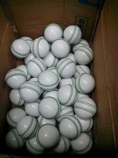 a cardboard box filled with white and green balls