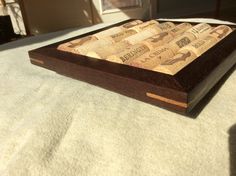 a wooden box with wine corks in it sitting on a white tablecloth covered surface