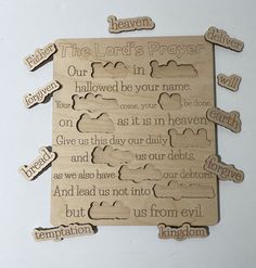 a wooden plaque with the words heaven, the lord's prayer and clouds on it