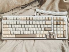 a computer keyboard sitting on top of a bed