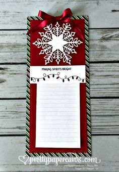 a red and white paper with a snowflake design on it, attached to a clipboard